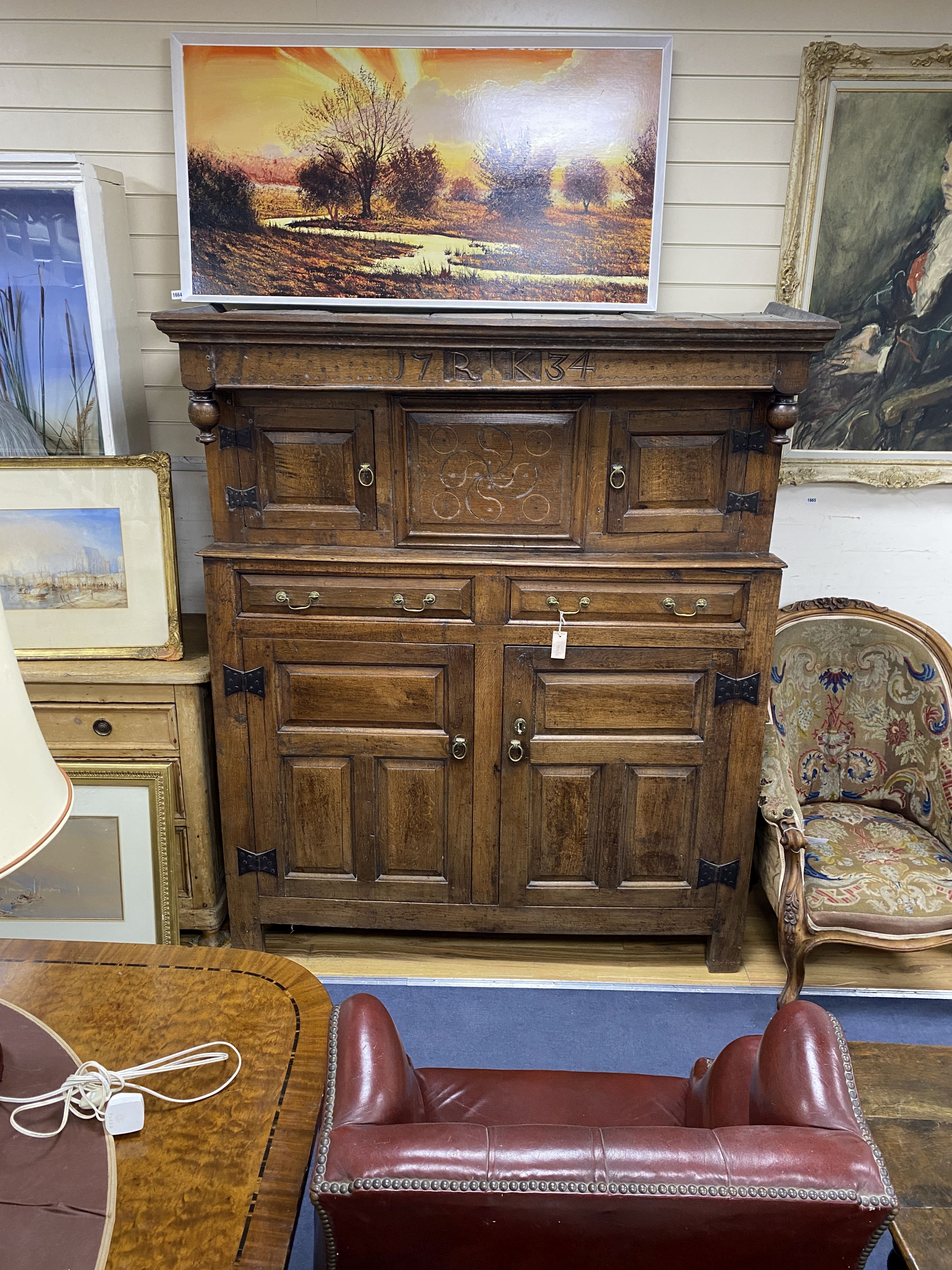 An 18th century oak court cupboard dated 1734, length 145cm, depth 55cm, height 176cm